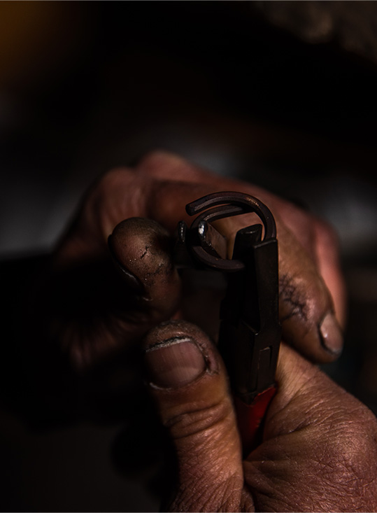 laboratorio orafo bari, dettaglio mani artigiano che lavorano il metallo in maniera tradizionale per creare anello su misura